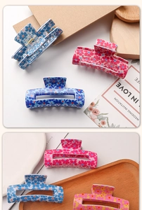 Detail of floral print hair claw clips in pink, blue and orange with metal spring