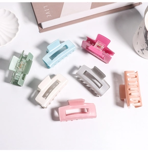 Gros plan sur des pinces à cheveux rectangulaires aux tons macaron sur une table