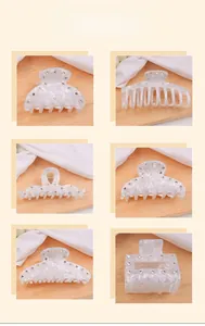Détail de pinces à cheveux motif marbre avec strass et ressorts dorés sur soie
