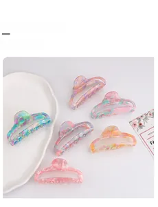 Détails de six pinces à cheveux colorées à texture marbrée aux tons pastels sur fond blanc