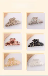 Detail view of large hair claws in marble amber, tortoiseshell, and grid textures