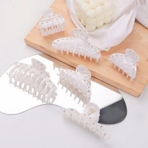 Ensemble de pinces à cheveux marbrées avec strass disposé sur un miroir décoratif chic