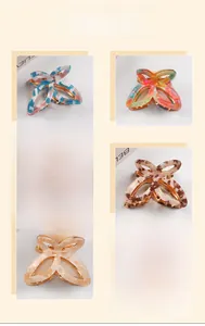 Detail showing six colorful butterfly hair claws in acetate and gold metal spring