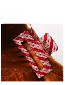 Detail of 8cm red and white striped hair claw clip with glitter finish on hair