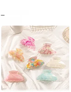 Vista dettagliata di varie grandi mollette per capelli in PVC colorato su lino