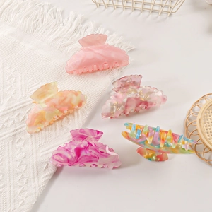 Set di cinque mollette per capelli colorate in PVC con motivo marmoreo su sfondo bianco