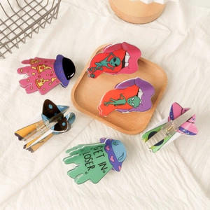 Cartoon UFO and alien hair clips in vibrant colors displayed on a wooden tray