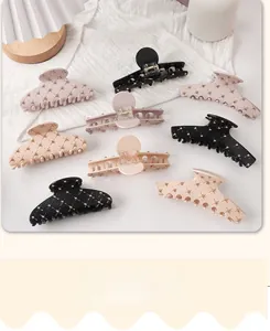 Close-up of set of 8 acrylic hair claws with gold stud accents on white fabric