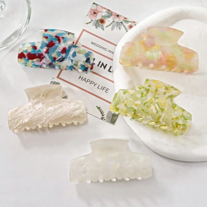 Assortiment de pinces à cheveux en acétate aux motifs floraux sur plateau décoratif