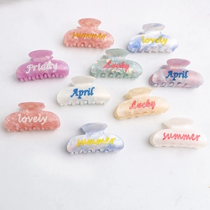 Pinces à cheveux en acétate coloré avec lettres anglaises et texture marbrée