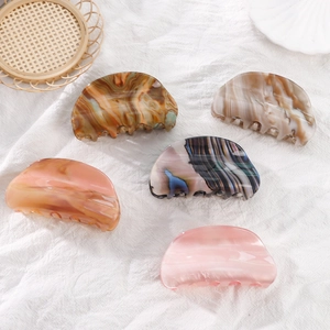 Five-piece set of 9cm acetate hair claws in marble and amber patterns on white fabric