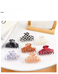 Flat lay of diverse acetic acid hair claw clips in plaid and marble textures