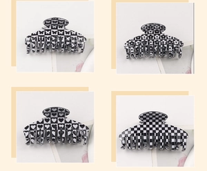 Detail showing checkered hair claws with butterfly flower and heart patterns in black and white