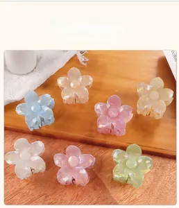 Macro display of colorful iridescent plumeria hair claws in seven aesthetic shades