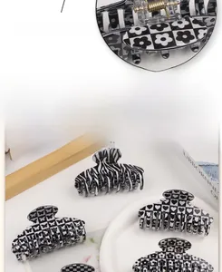 Detail of premium black and white checkered hair claw clip with strong golden metal spring