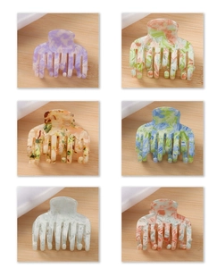 Detailed macro view of six colorful marble texture acetate hair claws on silk
