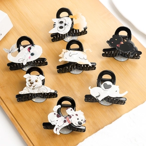 Cute acetate hair clips with cartoon cat, dog, and elephant designs on a wooden tray