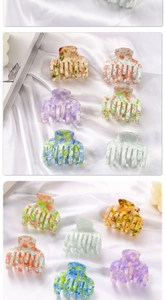 Close-up of marble pattern hair claws set in assorted colors on soft white satin
