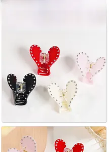Détail des pinces à cheveux en forme de cœur avec strass en rouge, rose, blanc et noir