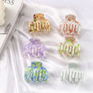 Set of 6 colorful acetate hair claws with marble textures and floral patterns on silk