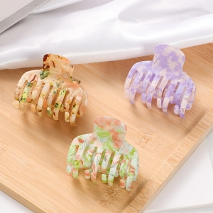 Three-piece acetate hair claw clips with colorful marble texture and amber finish