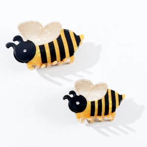 Pinces à cheveux en forme d'abeille en acétate avec des yeux en strass sur fond blanc