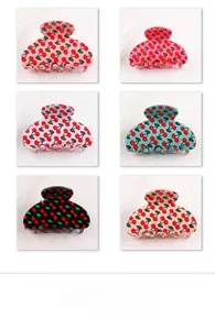 Close-up of hair claw clips set in six colors with vibrant cherry patterns