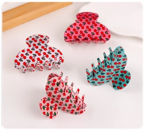 Detailed macro view of large hair claws with cherry prints in various pastel colors