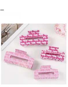 Detailed macro view of acetate hair claw clips with pink gradient and Bride engraving