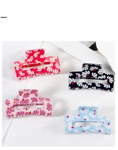Detail view of square floral hair claw clips with daisy patterns in four vibrant colors