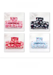 Detail showing four floral daisy pattern hair claw clips in pink, black, red and blue