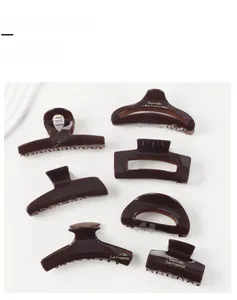Set of seven tortoise shell hair claw clips in varied shapes with gold barrette lettering