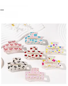 Detail view of 7-piece set colorful acrylic hair claw clips with floral and heart patterns