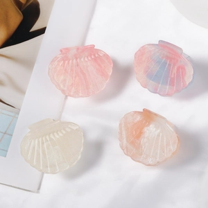 Set of 4 shell-shaped glitter hair claws in pink, blue, white, and orange resin