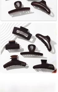 Deep coffee resin hair claws with Barrette La France engraving on textured background