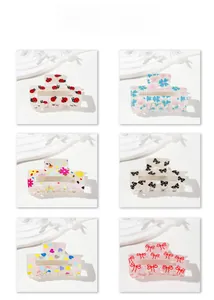 Detail view of six acetate hair claws featuring diverse patterns like floral and hearts