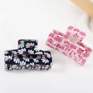 Floral print hair claws set with daisy patterns and heart accents in navy and pink colors