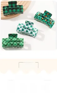 Close-up of four green hair claws featuring clover, plaid, and leopard patterns