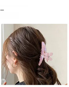 Dettaglio della grande molletta per capelli a orecchie di coniglio rosa su capelli mossi
