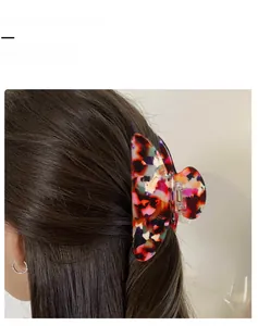 Detail shot of a large tortoiseshell hair claw clip holding a low ponytail hairstyle