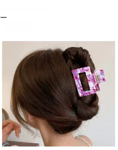Detail showing marble-textured pink hair claw clip with strong metal spring mechanism