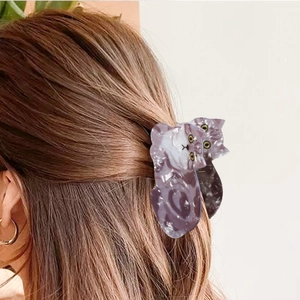 Cute cat-shaped hair claw clip in purple marble acetate shown on a model hair