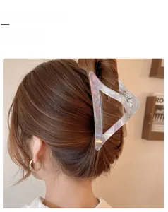 Detailed view of an iridescent triangle hair claw clip worn for an elegant hairstyle