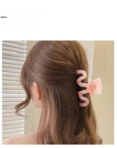 Detailed view of a pink marble texture hair claw clip in a stylish wavy Z-shape design
