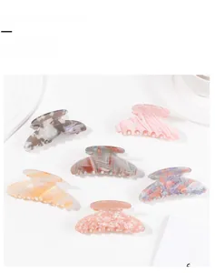 Flat lay of six colorful acetate hair claw clips with marble and floral patterns