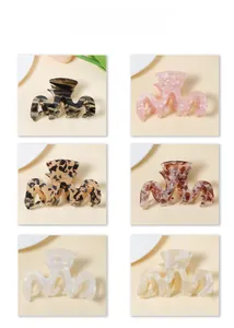 Close-up of six premium acetate hair claws in assorted pearlescent and tortoiseshell patterns