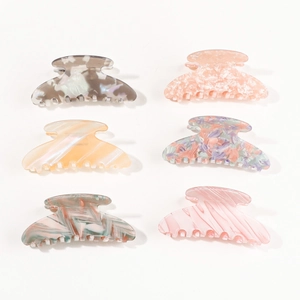 Set of six colorful acetic acid hair claw clips in various patterns on white background