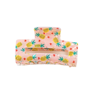 Pink rectangular resin hair claw clip with yellow pineapple and red heart patterns