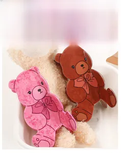 Dettaglio di fermagli per capelli a forma di orso rosa e marrone con trama marmorizzata