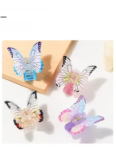 Detail showing four assorted butterfly hair claw clips in colorful gradient resin finishes